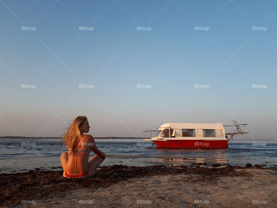 Woman alone at the beach near boat