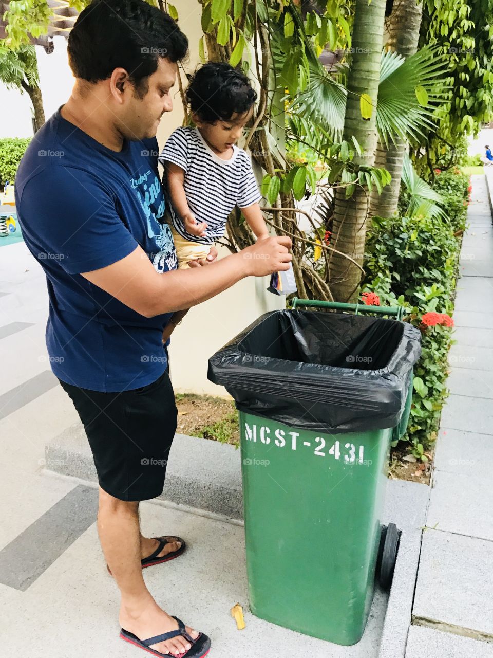 Dady teaches Son about disposal of waste.