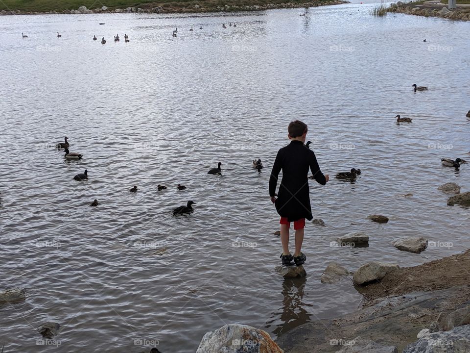 A Lake in Utah. A child standing on a rock on the lake. ©️ Copyright CM Photography