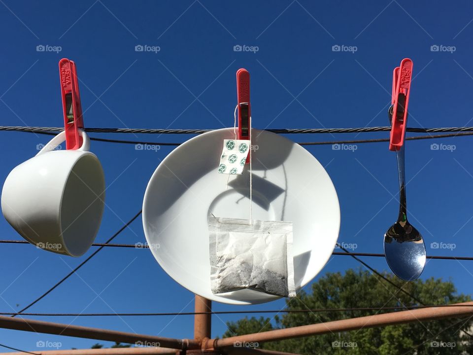 Solar and wind power. Dishes and tea bag hanging to dry on a clothesline imagery tongue in cheek 
