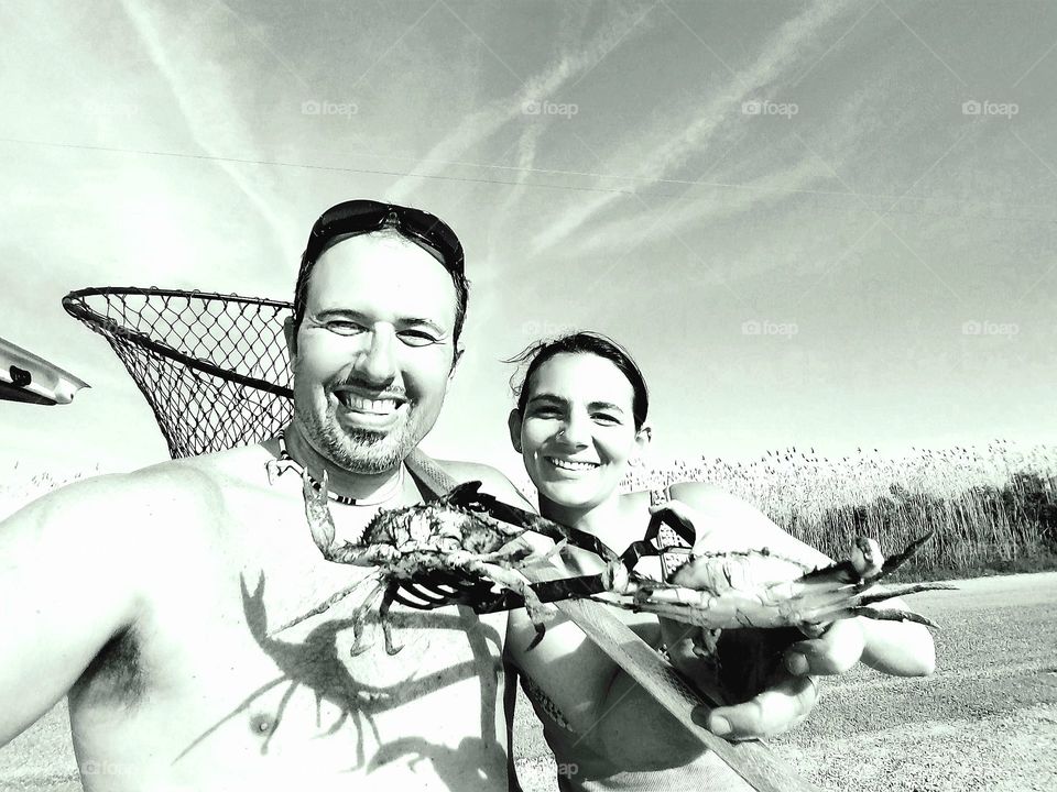 black and white photo of a couple each holding a blue crab they caught off of the Gulf of Mexico near Bridge City Texas United States of America 2018