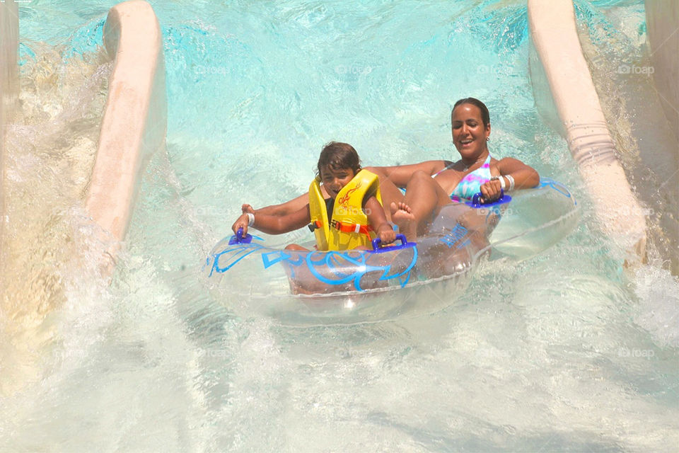 Mother and son enjoying ride in water park