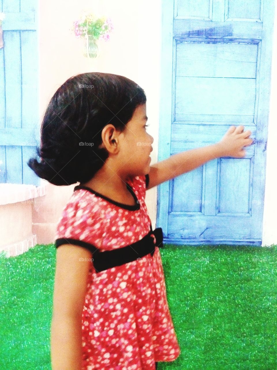 Little girl tries to open the blue door