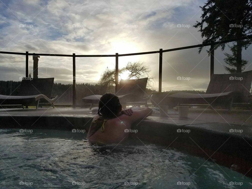 My girlfriend watching the sunrise from our hot tub.