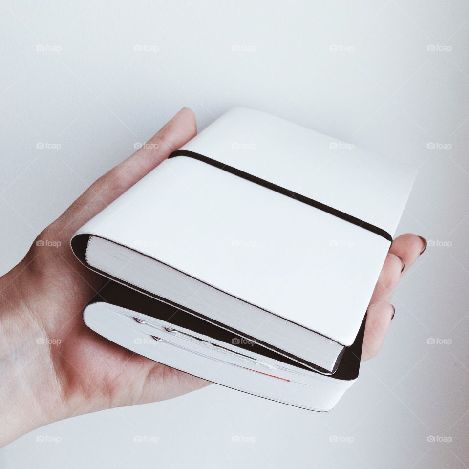 black and white notebooks in the hand