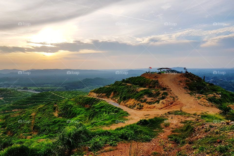 Scenic view of hills against sunset sky