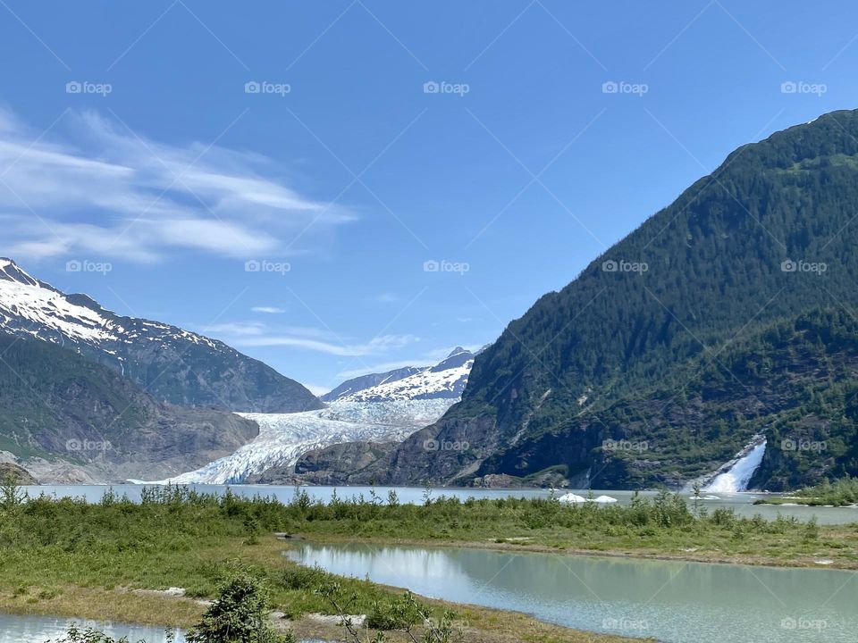 Alaskan vacation at Hubbard glacier with big blue skies and a waterfall in Alaska