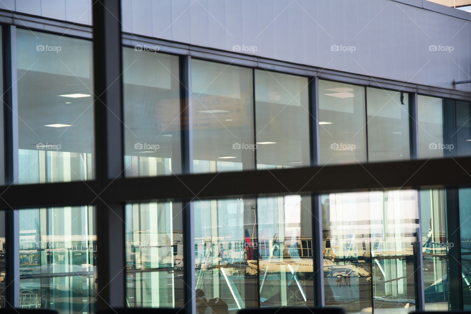 Commercial airliners can be seen through  reflections of windows at John F. Kennedy airport in Jamaica, Queens, New york.