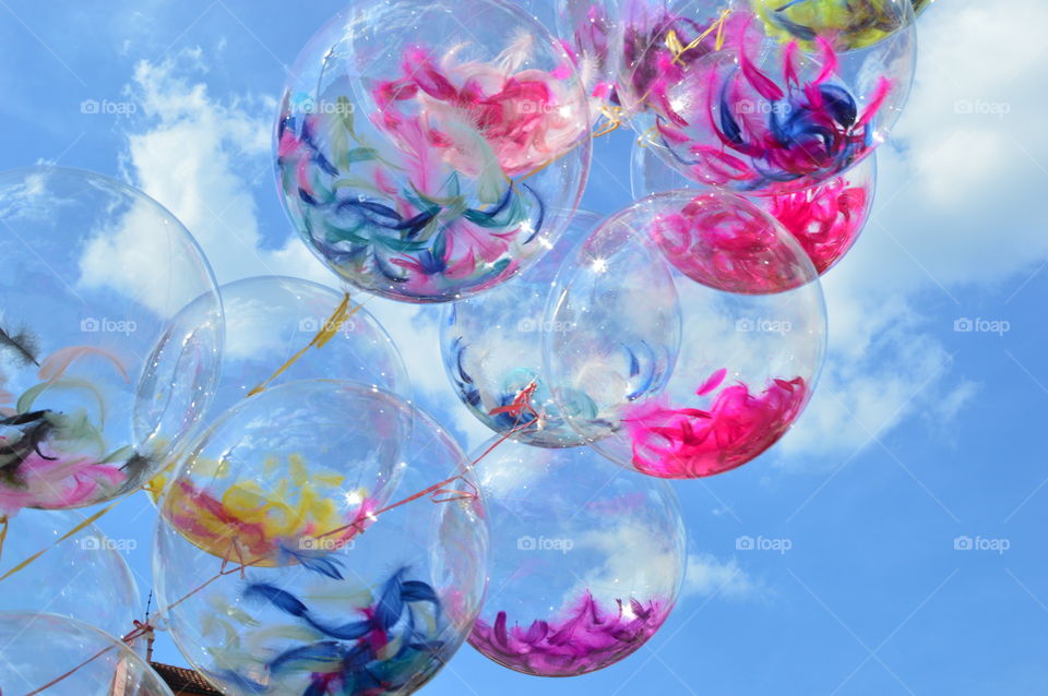 transparent balloons with colored feathers