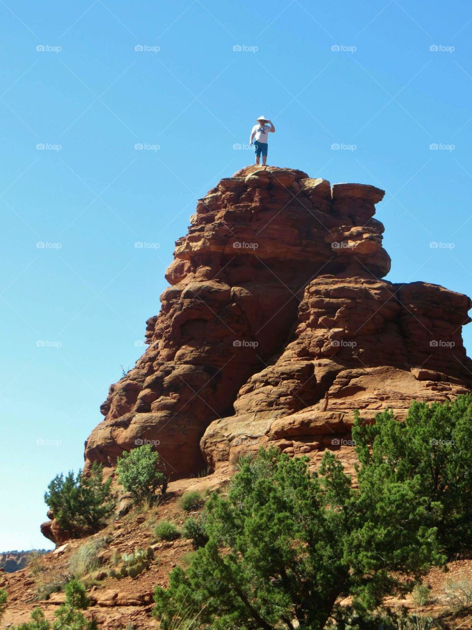 On Top of The World. Man climbing on top of a rock at a vortex in Boynton Canyon, Sedona, AZ