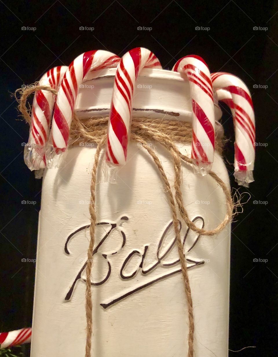 White painted Ball mason jar with candy canes decoration 
