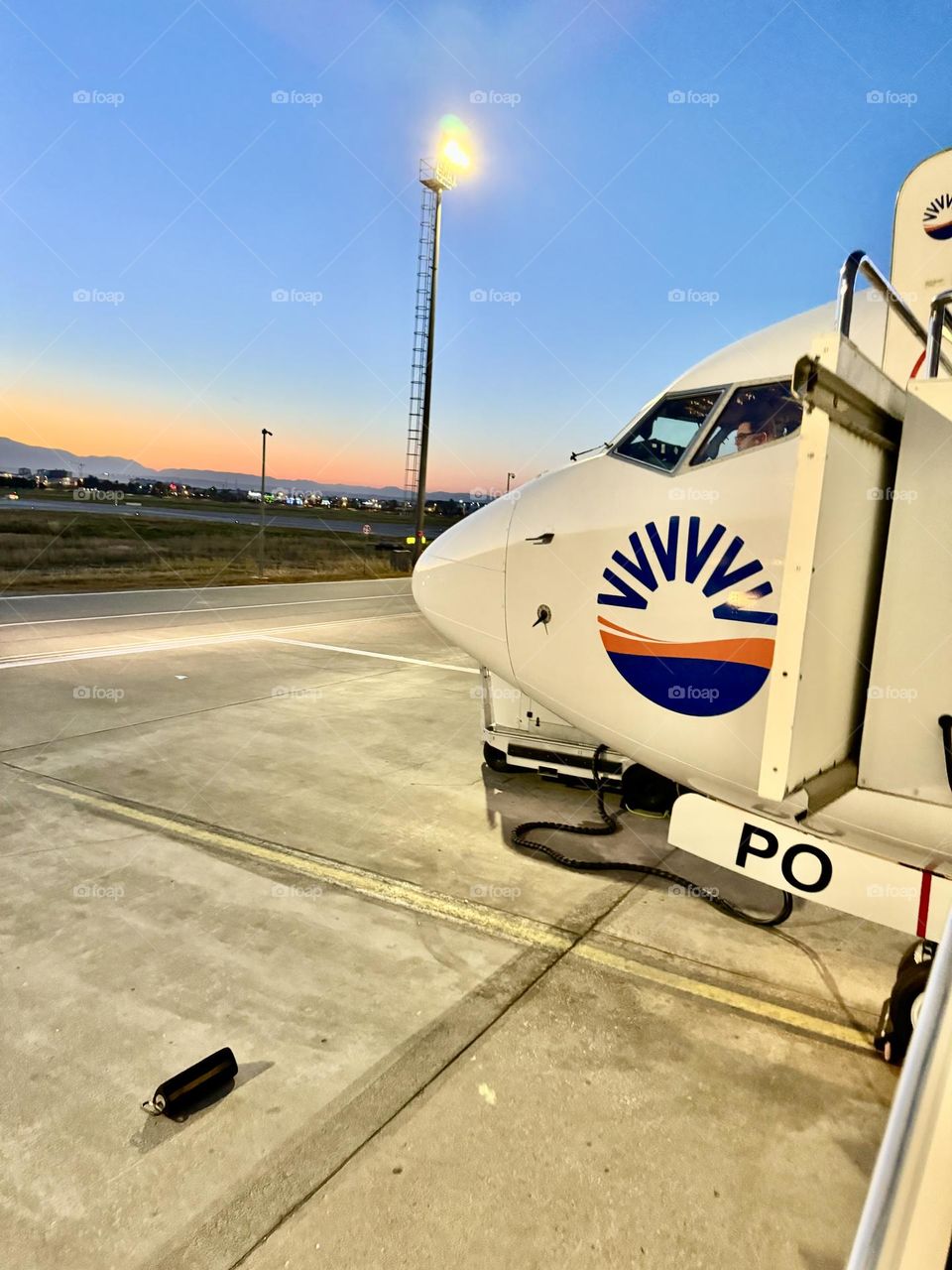 На фото изображен нос большого самолета, стоящего на земле. Самолет кажется внушительным и мощным, его обтекаемый фюзеляж блестит на солнце.
Четко видны окна кабины пилотов, слегка тонированные для защиты от яркого света.