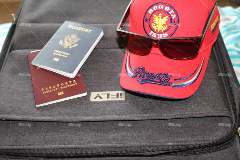 Packing my suitcase for summer vacation. Colombian red cap, sunglasses and passports 