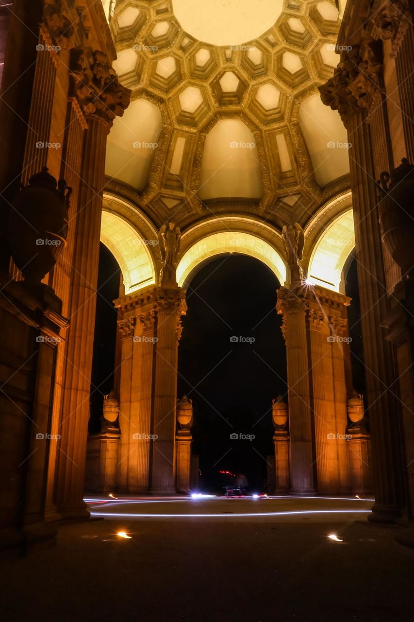 Palace of Fine Arts in San Francisco California at night under the dome with a light ring glowing at the base from motor scooters circling on a Friday night 