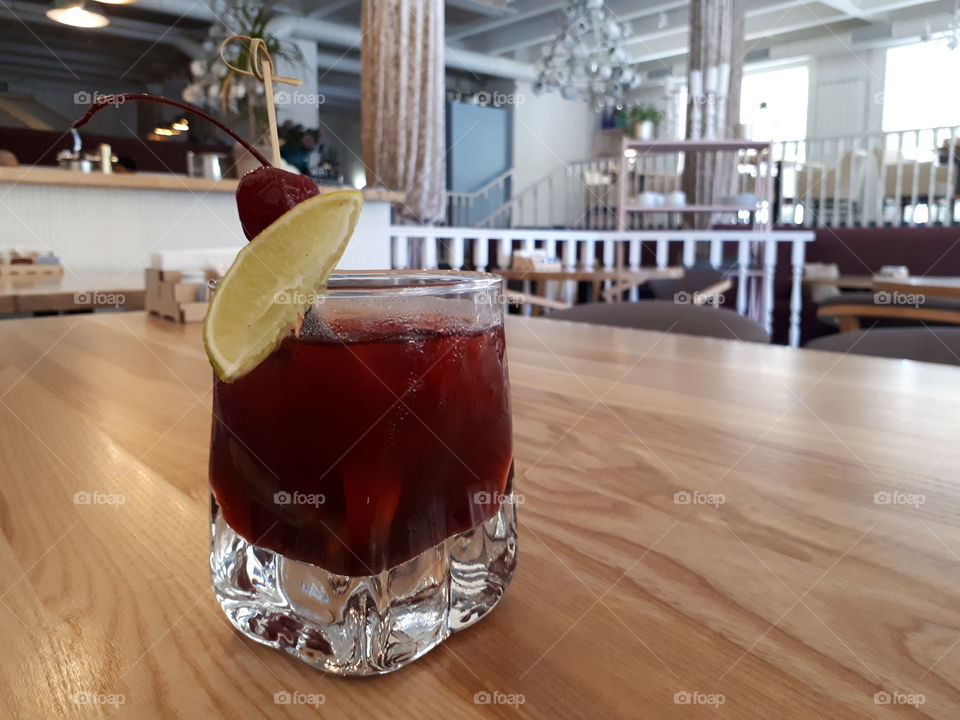 Glass with cocktail at the wooden table