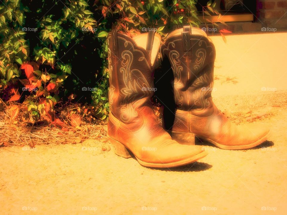 Dirty, broken in and well worn cowboy boots. 