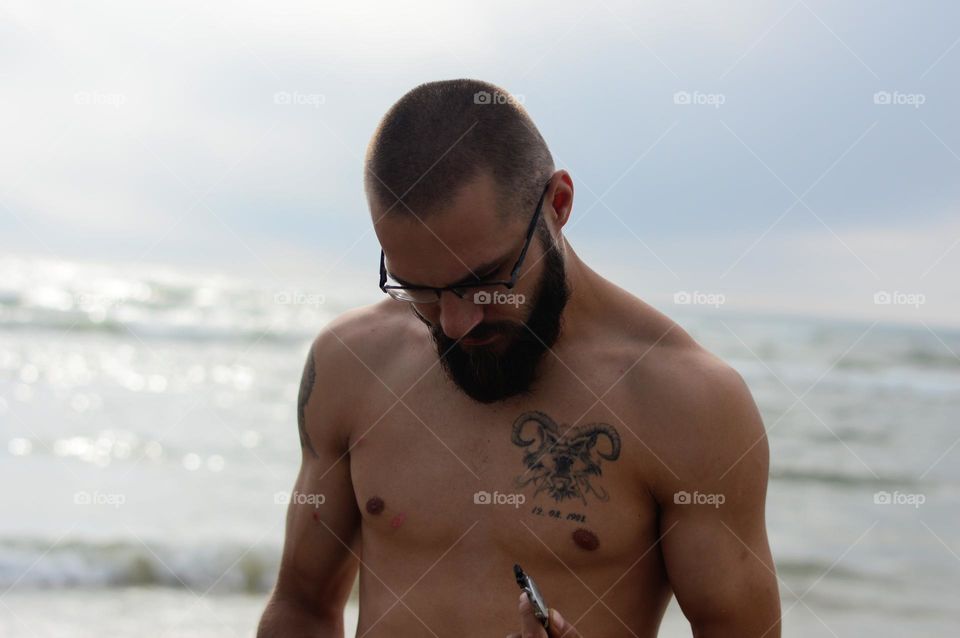 man with tattoo on the beach