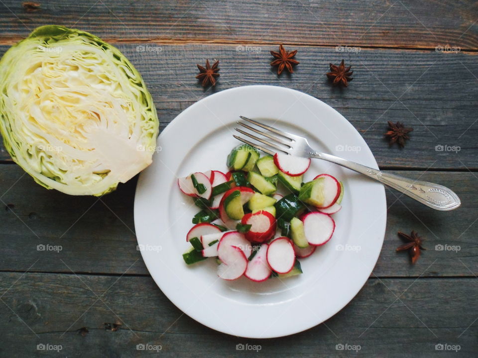 Vegetable salad in plate on wooden table