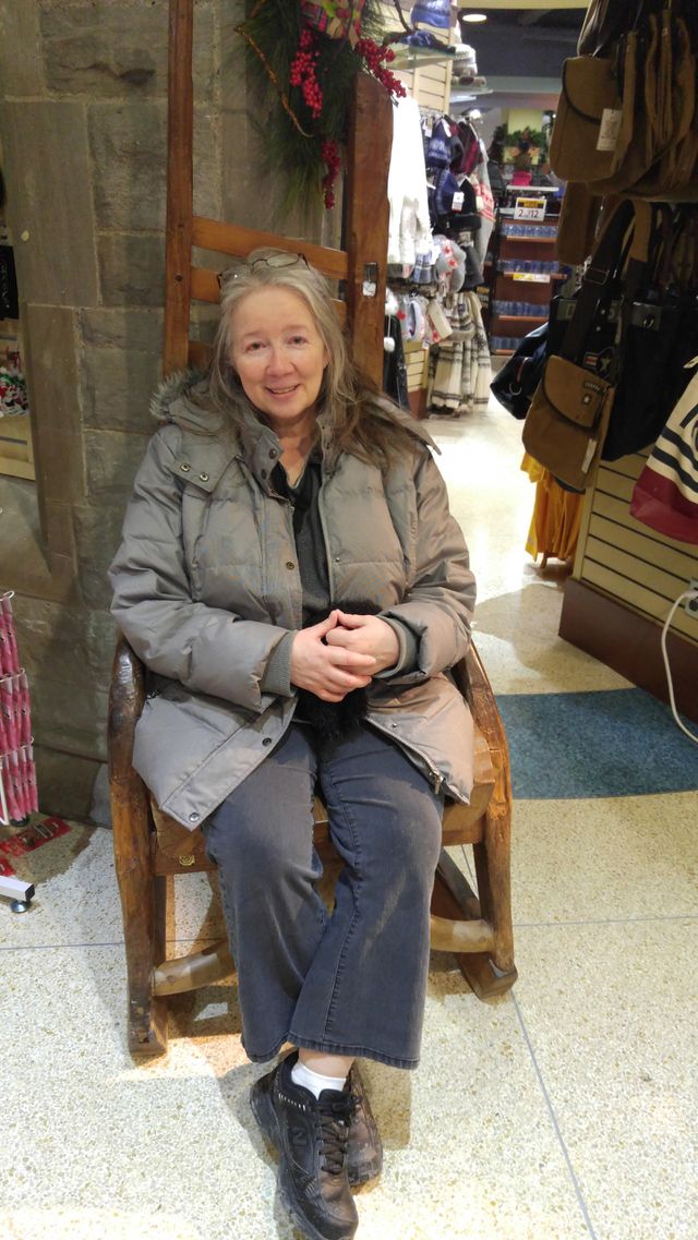 Senior woman sitting on chair in shop
