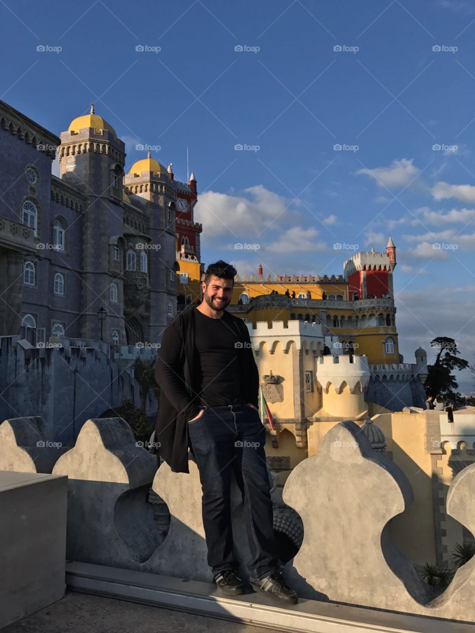 Happy man standing near castle
