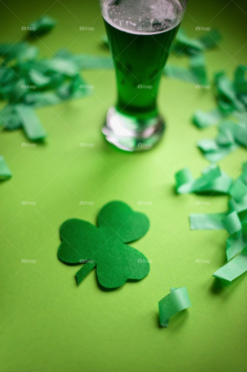 Beer glass and leaf cut out on green background