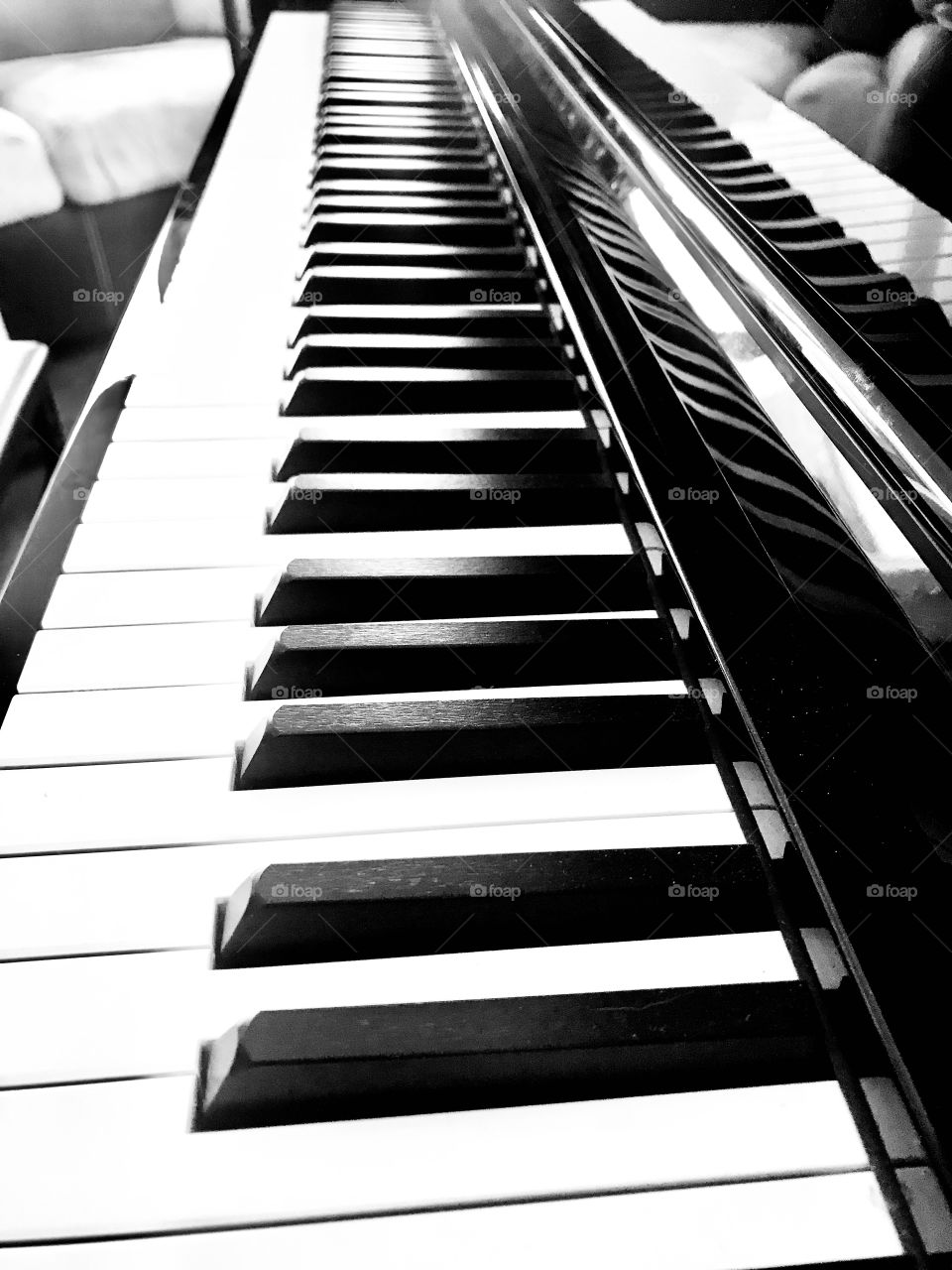 Black and white photo of gorgeous baby grand pianos sleek black and white keys. 