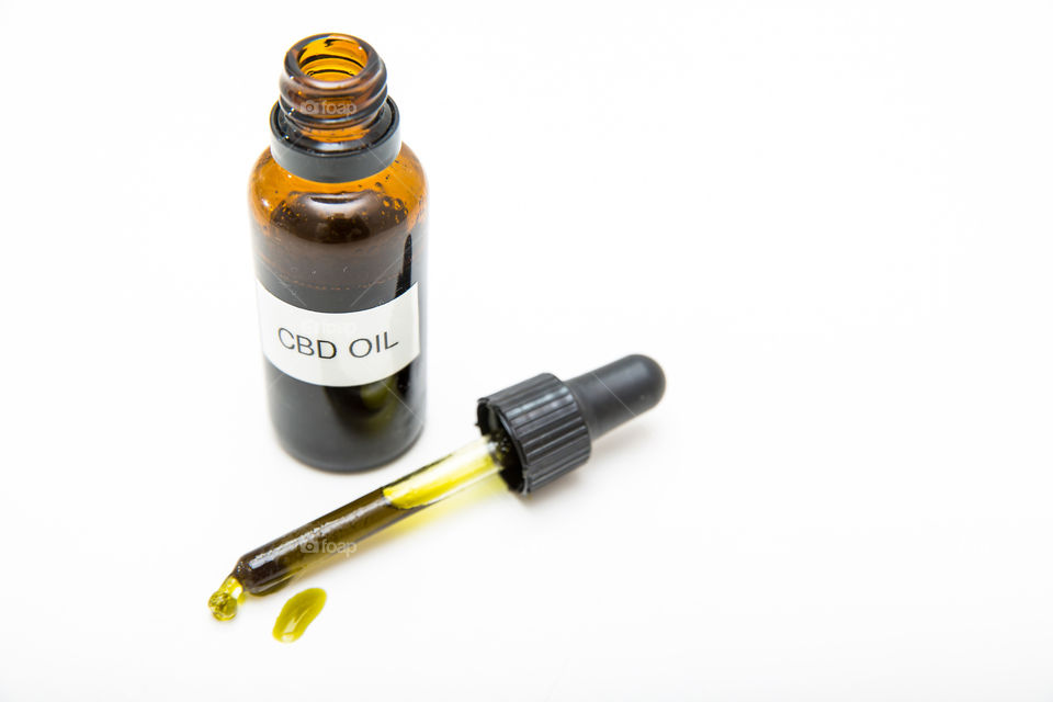 Product cbd oil bottle with dropper and oil on pure white background