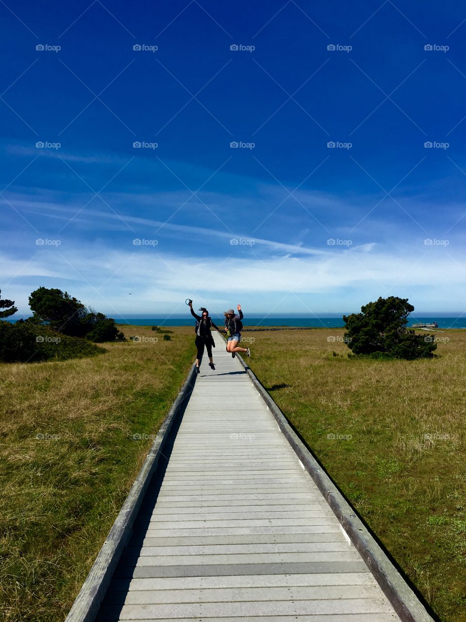 Jumping on the boardwalk by the sea