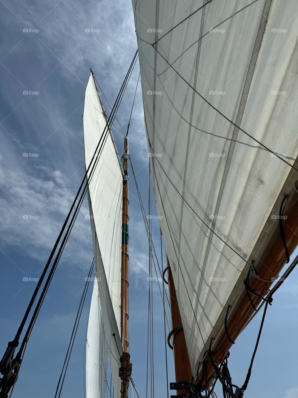 Looking up at sails and rigging on a sailboat 