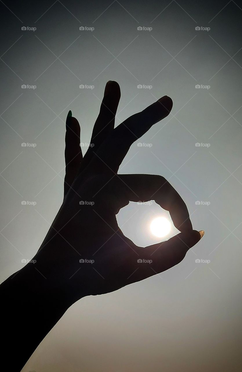 In this photo I captured hand and sun. I captured a black and white photo by reflection of sun , without filter, reflection of sun