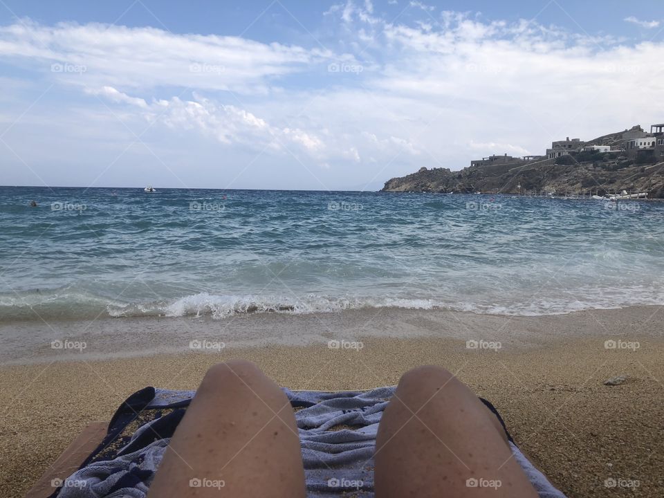 Lounging and sun tanning by the aegean sea in super paradise beach