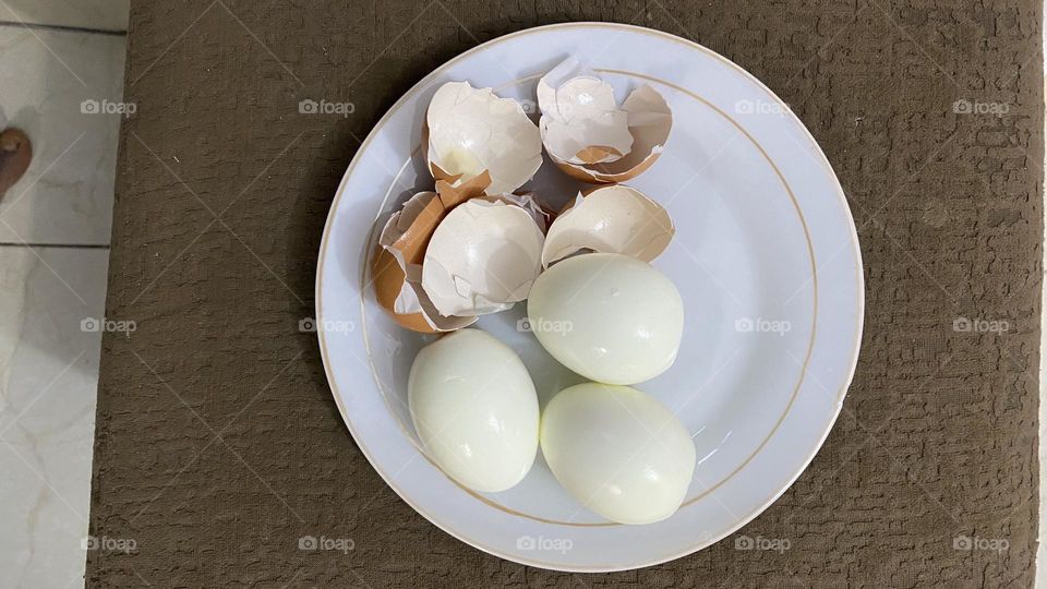 Eggs with shells on a white saucer 