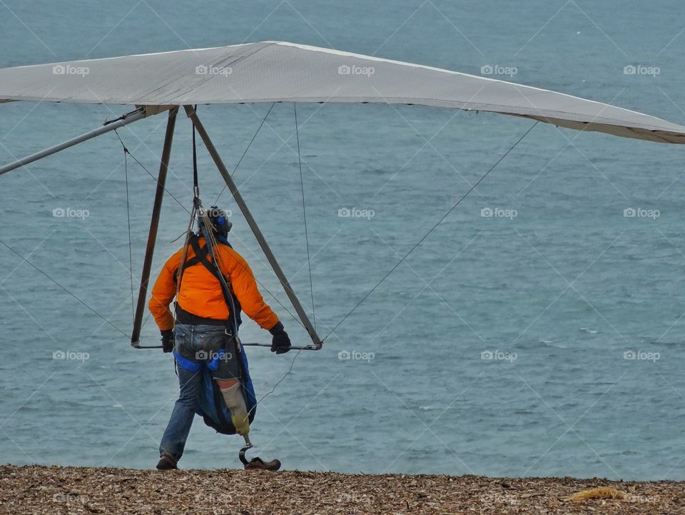 Disabled Hero. Paraplegic Adventurer With Artificial Limb Preparing To Fly A Hang Glider