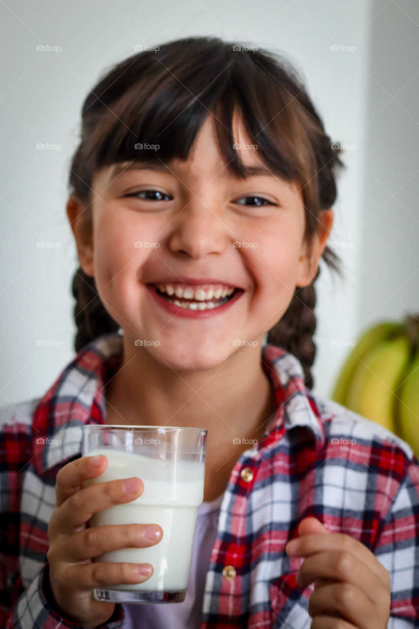 Happy little girl with a glass of milk