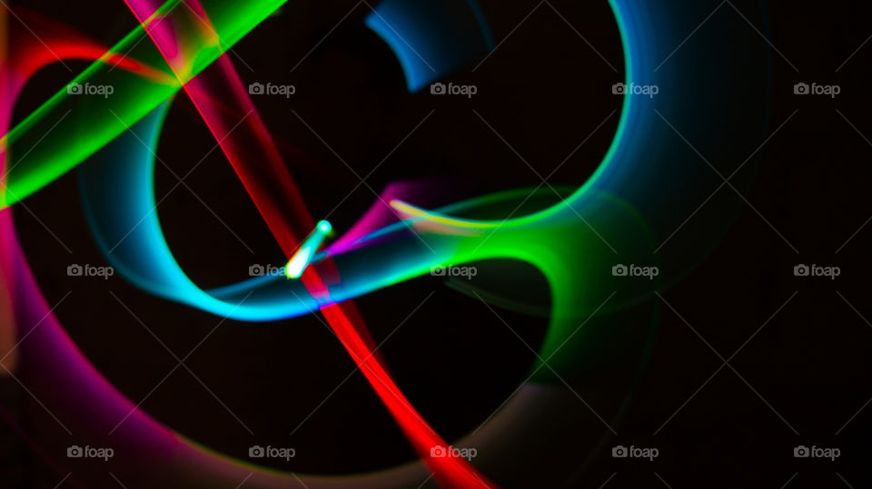 Drawing with a ray of light in the dark. Abstraction of involuntary forms and different shades of colors.