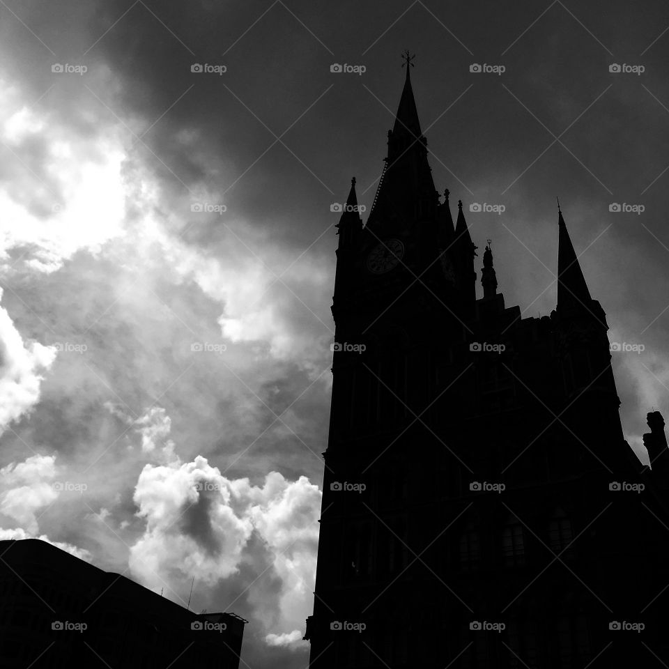 Silhouetted St Pancras Hotel against stormy skies 