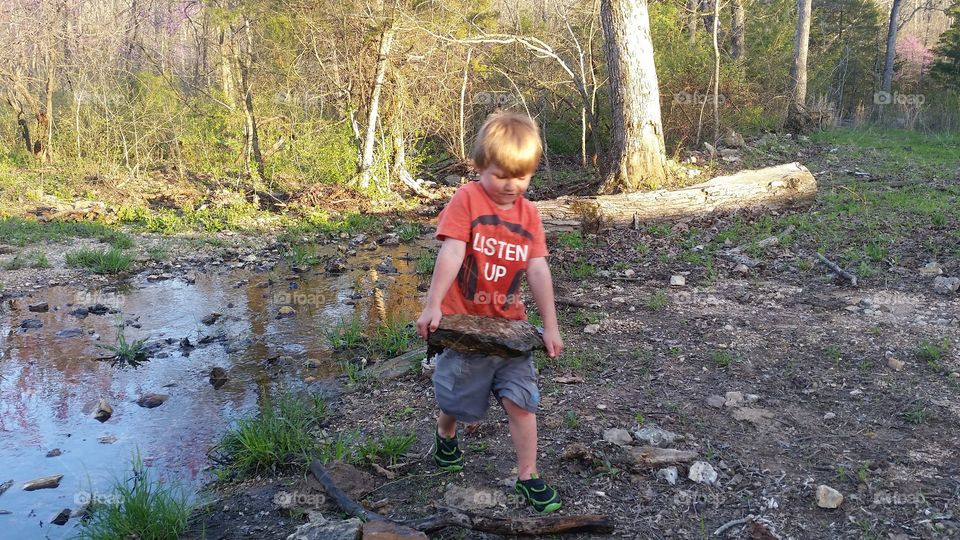 Boy carrying rock