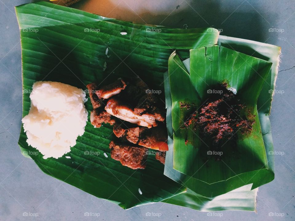 Thai food. Sticky rice and fried pork on banana leaves and chili.