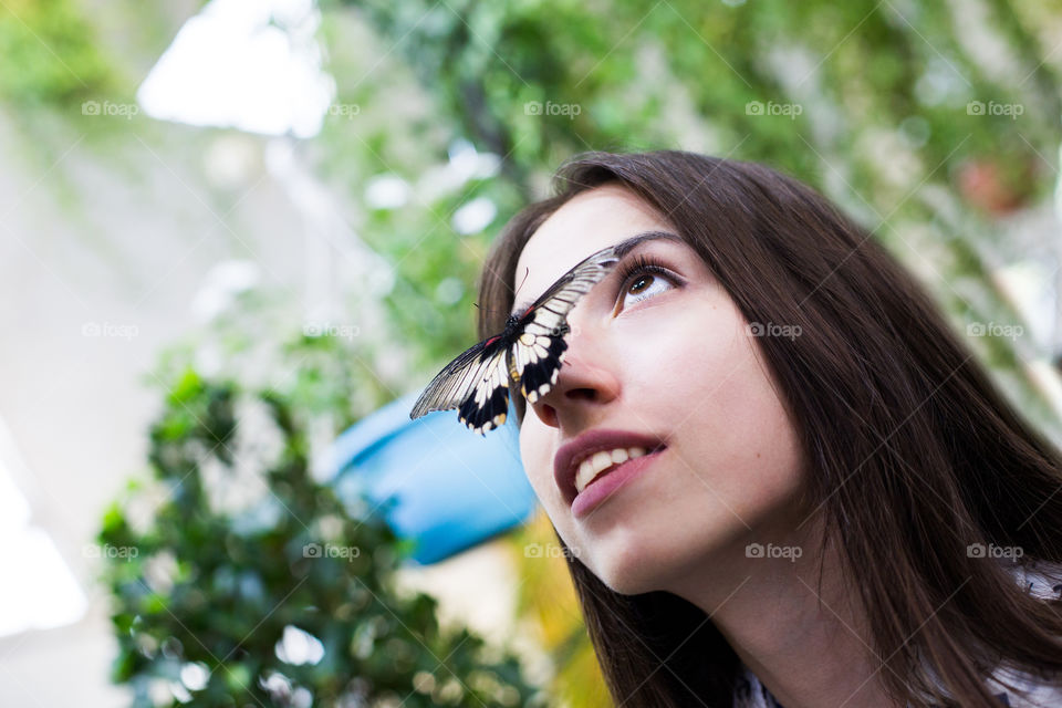 Funny butterfly sit on girl nose 