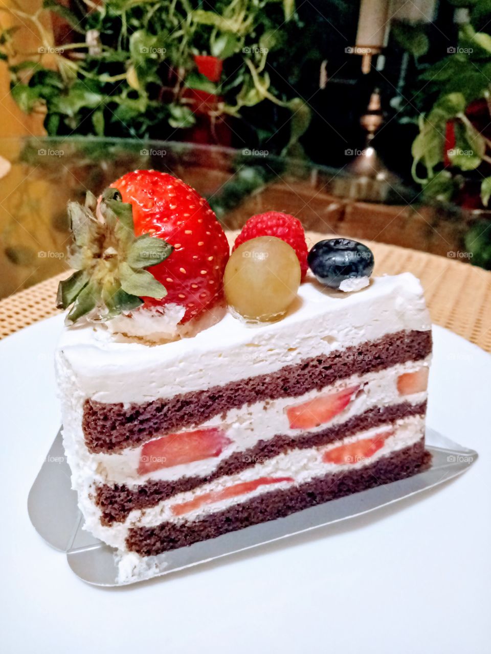 Strawberry cake in a white round plate. Dessert for the night. Fruits, layer. Tasty and yummy. 