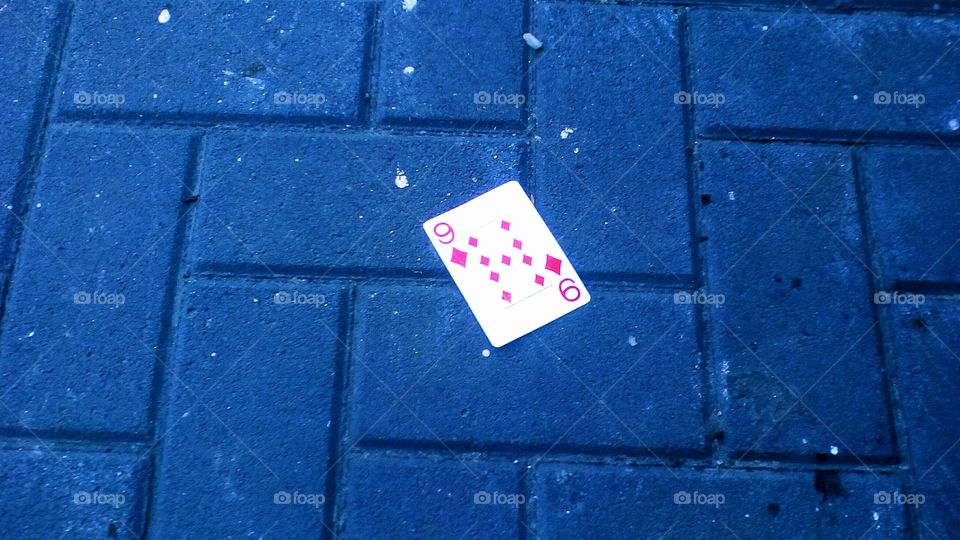One paper game card along blue cube
pavement outdoors