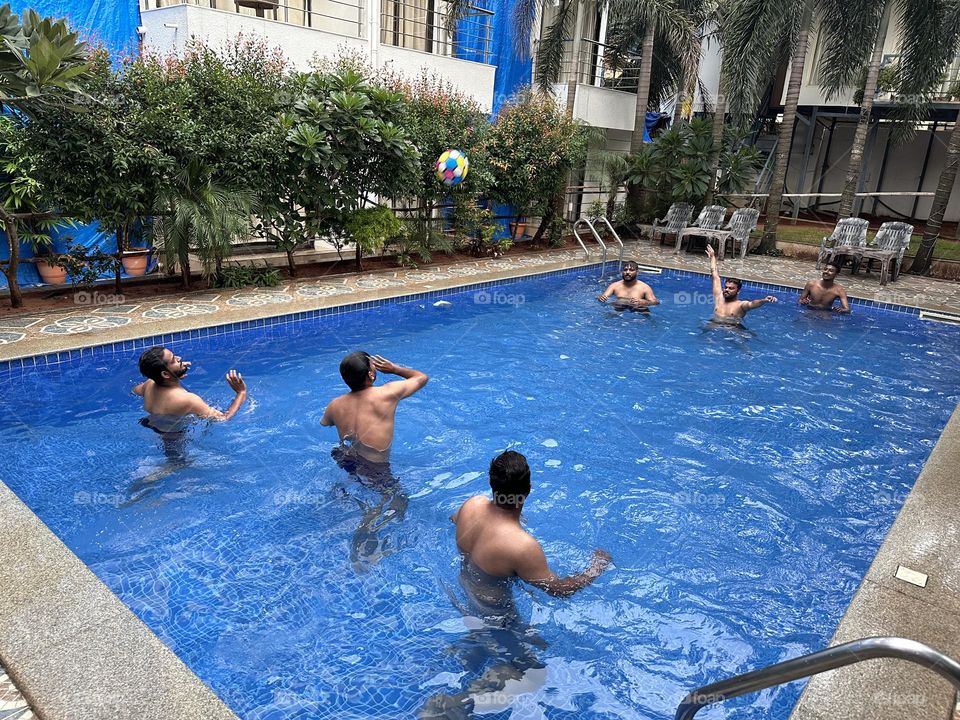 Enjoying in pool playing ball throw in summer