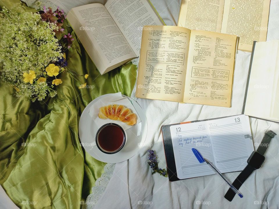 studying a book in bed and coffee.