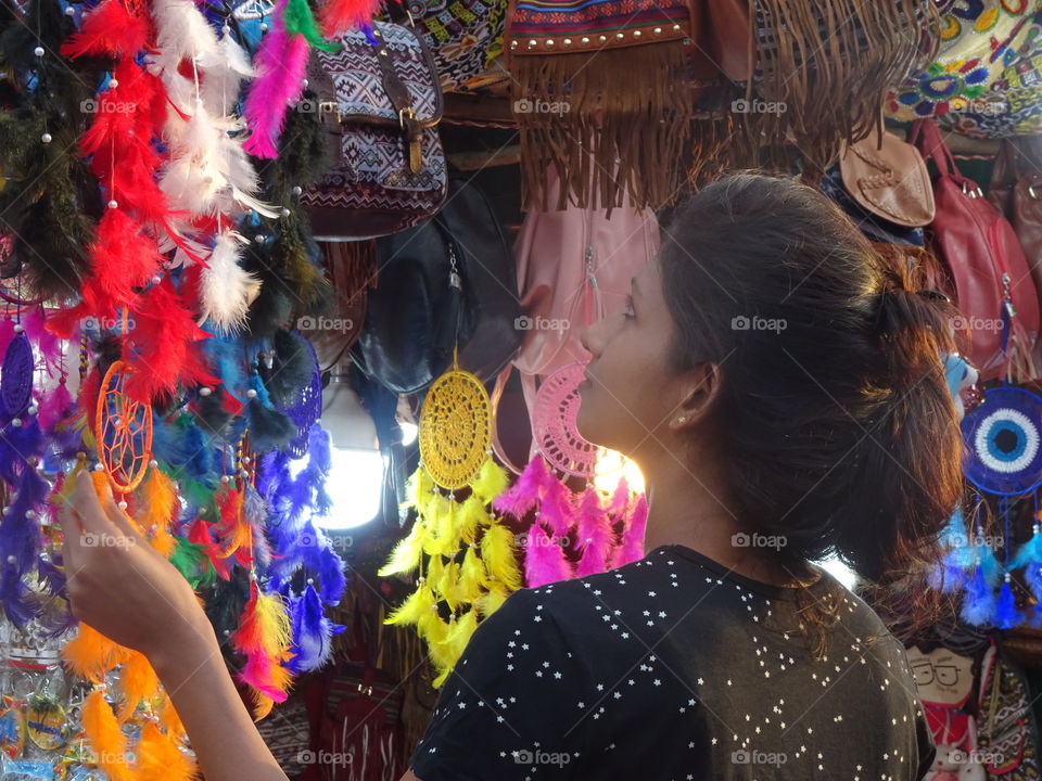 woman looking at colorful dreamcatchers...