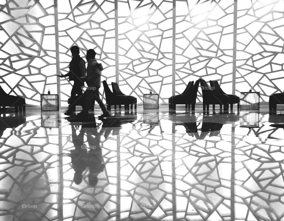 Street photo of people walking and their reflection on floor
