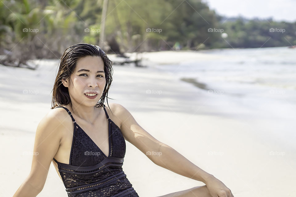 Portrait of Asian woman wearing a swimsuit on the beach.