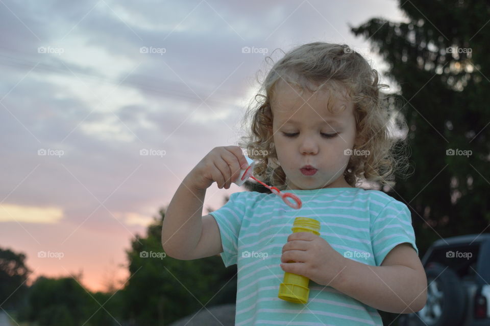 Girl blowing bubbles with bubble wand