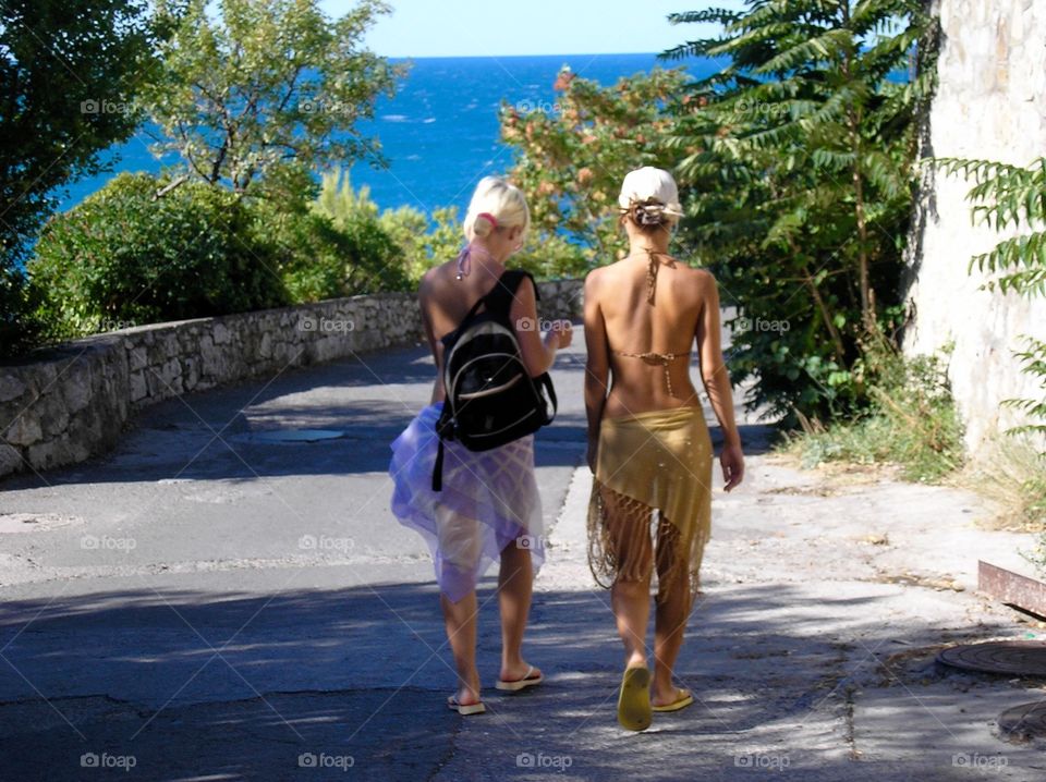 Two girls walking the way to the beach