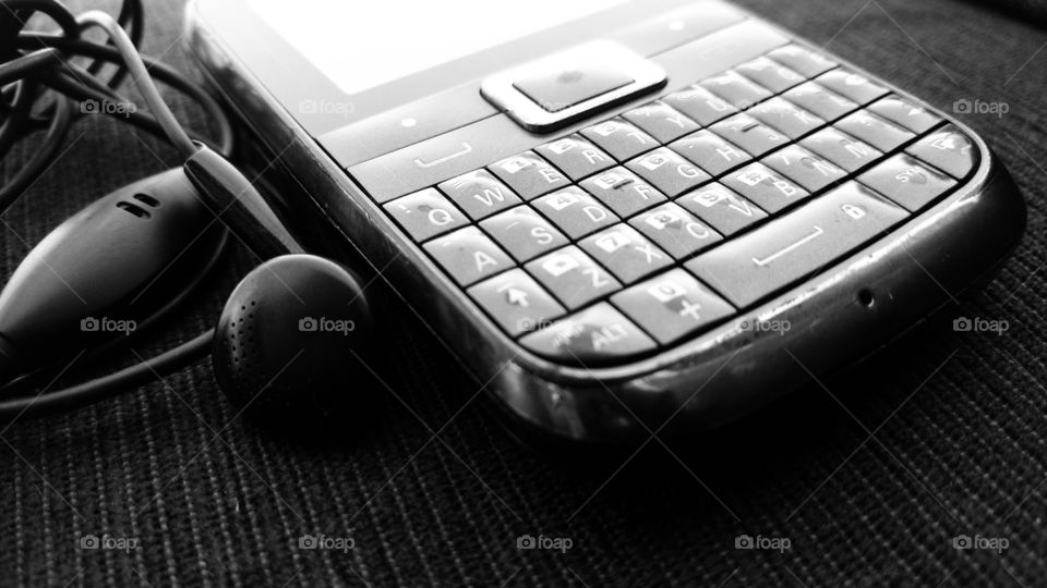 Velho celular. Teclado e fone.