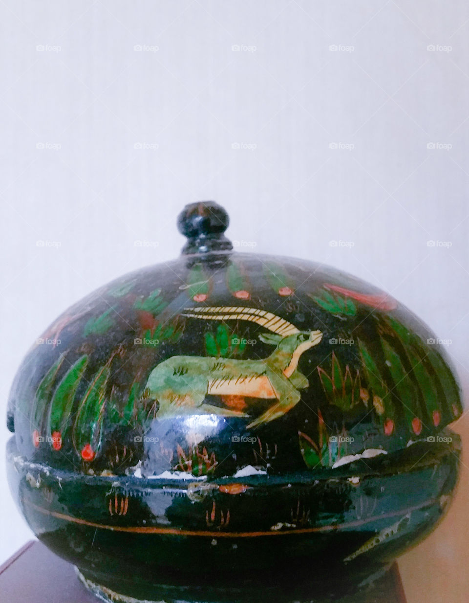 An old handpainted container with an antelope